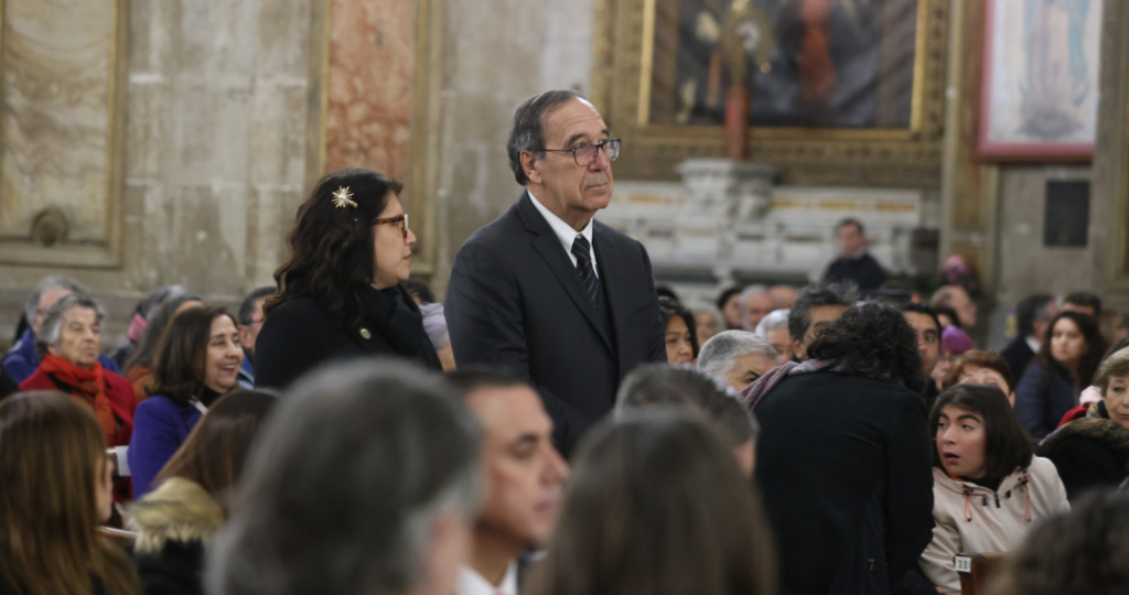 Fotografía de una persona de pie alrededor de otras en un entorno de iglesia