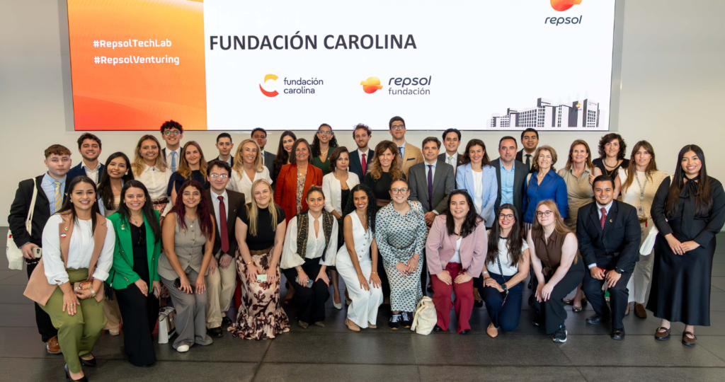 Fotografía de decenas de personas vestidas semi formal, de fondo se ve en grande el nombre Fundación Carolina