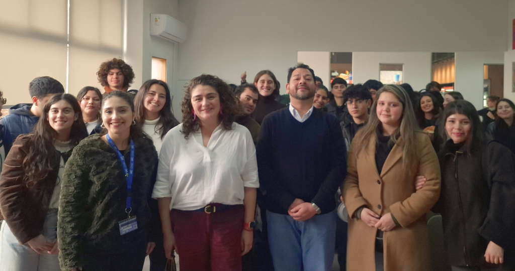 Fotografía de un grupo grande de personas de pie mirando a la cámara sonriendo