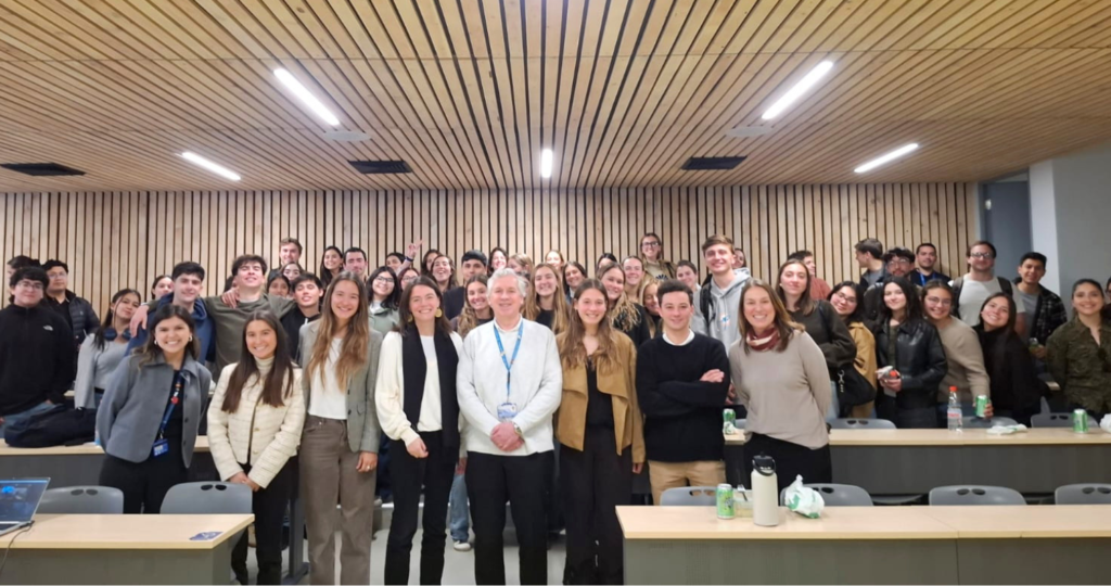 Foto de un grupo de decenas de personas sonriendo y haciendo gestos con las manos